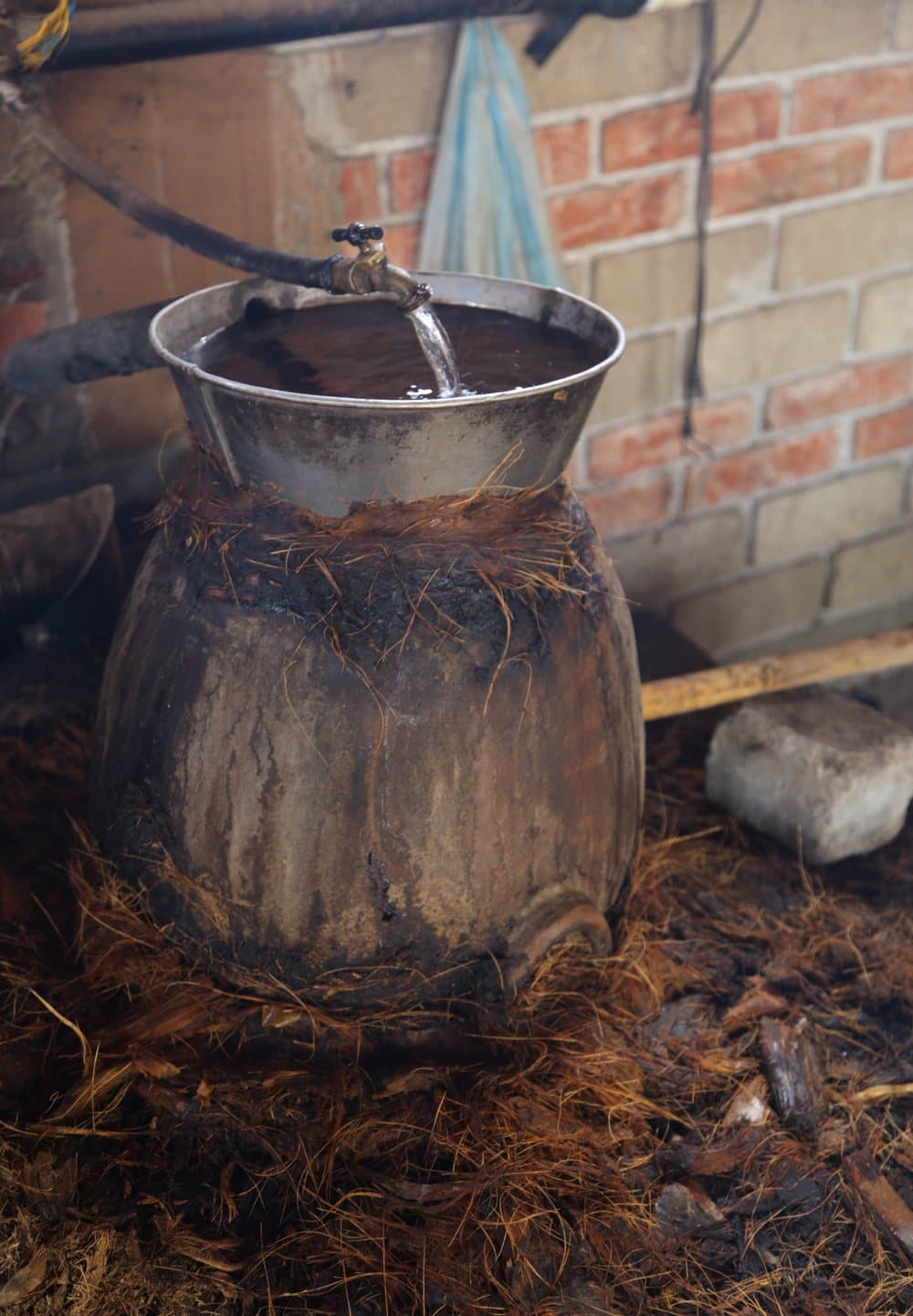 A clay pot still with a pan of cooling water on top